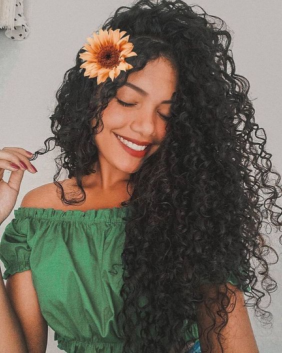 Imagem com cabelo cacheado com flor