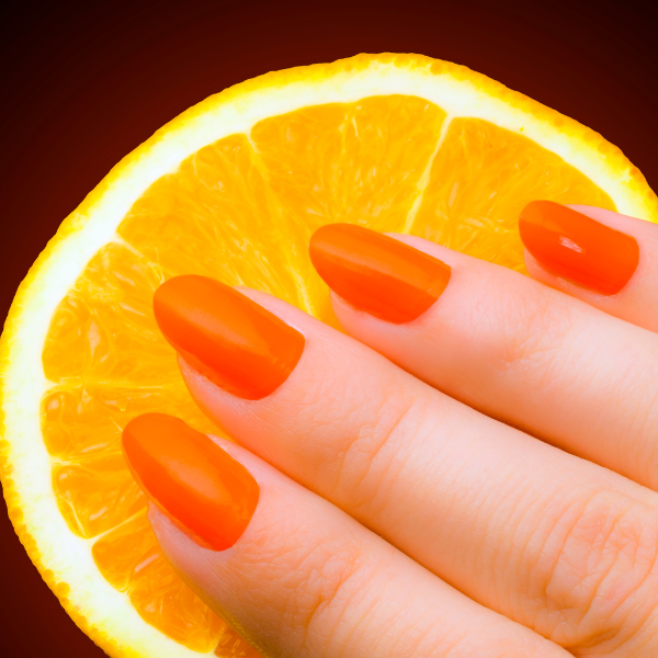 Imagem com unhas saudáveis e uma laranja