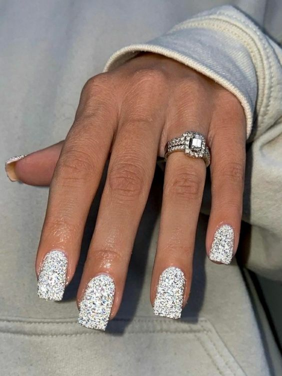 Imagem com unhas brancas com glitter quadradas e brilhosas