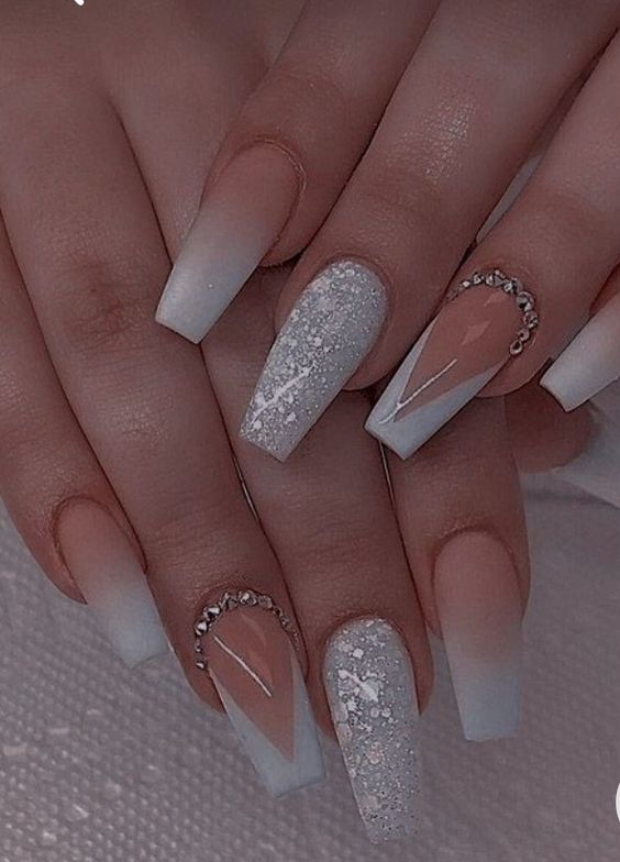 Imagem com Unhas brancas com glitter e pedrarias intercaladas com unhas boomer