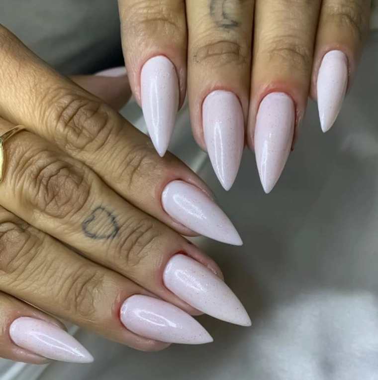 Imagem com unhas grandes stiletto brancas meio arredondadas 