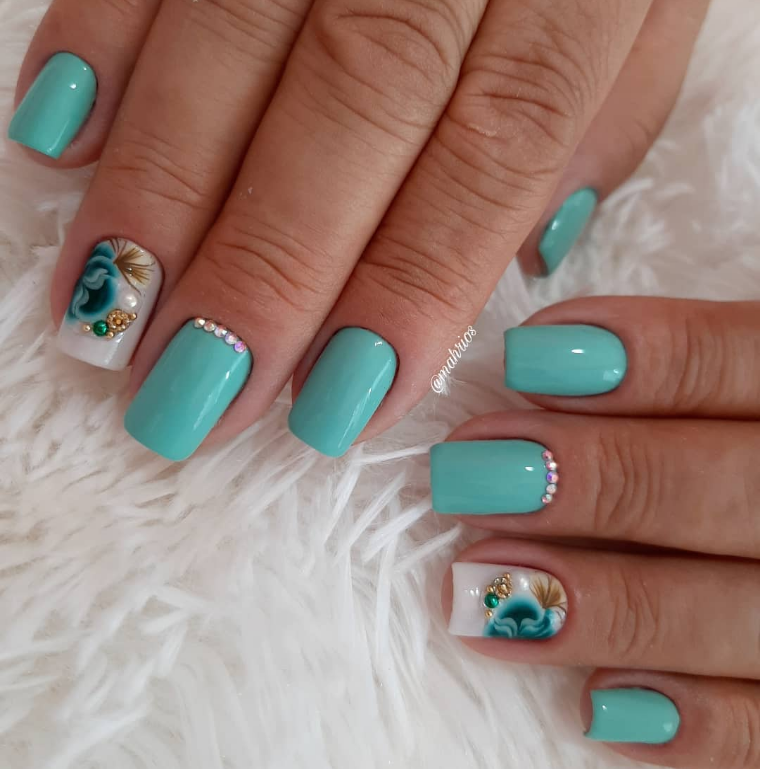 Imagem com unhas grandes verdes com pedras e decoração nas unhas anelares