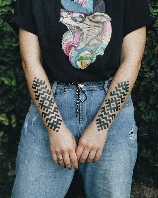 Imagem com tatuagem tribal feminina com traço maori