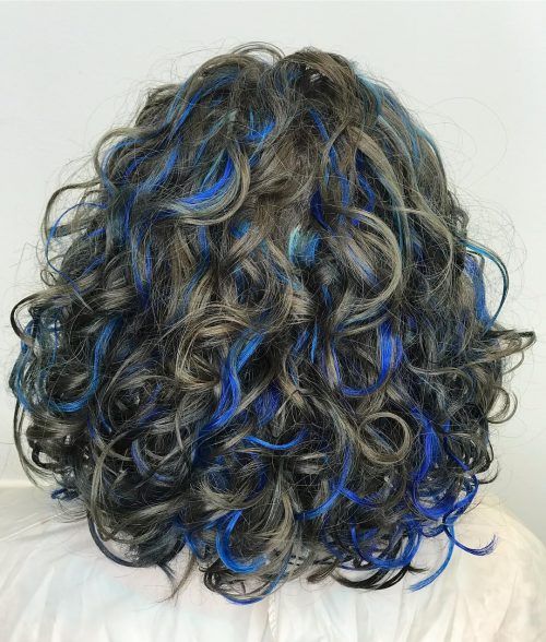 Imagem com cabelo cacheado pintado em mechas azuis