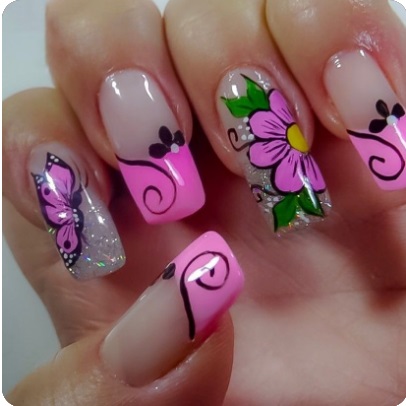 Imagem com unhas com esmalte rosa claro com decoração de flores