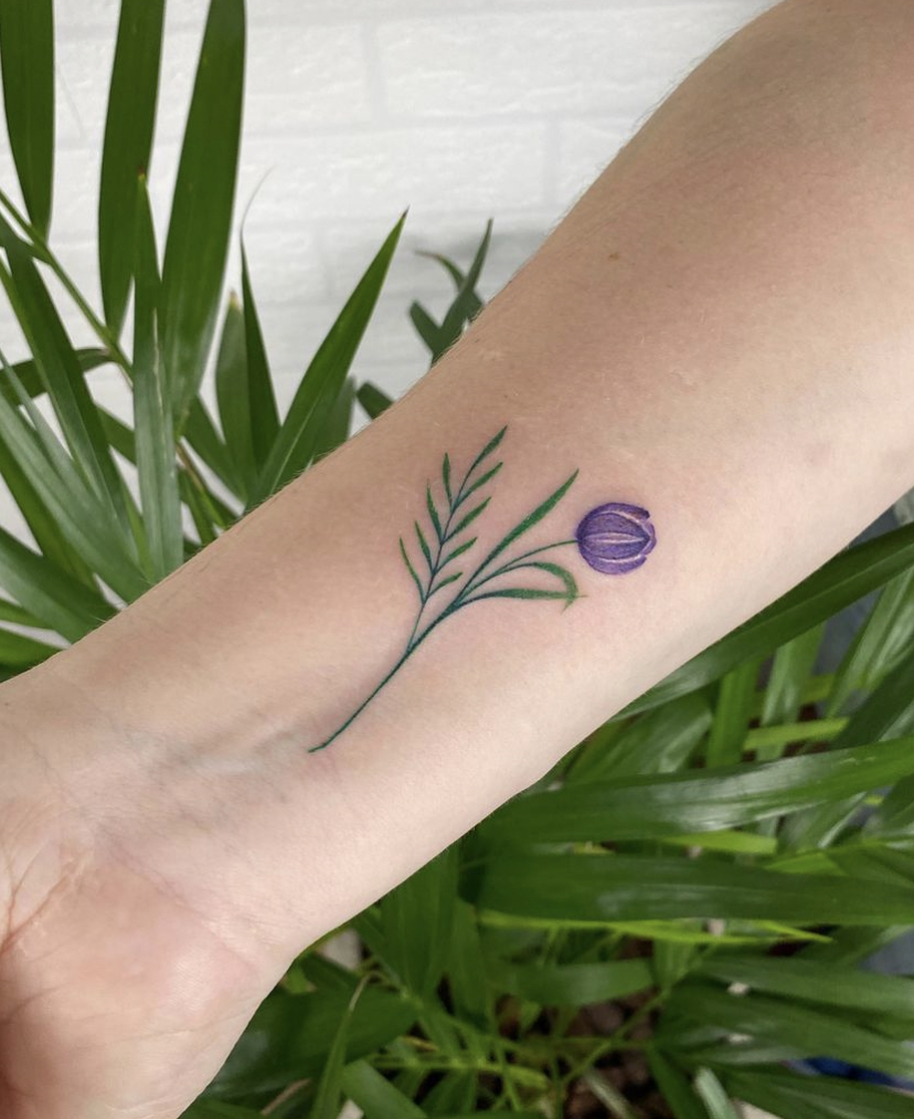 Imagem com tatuagem de tulipa roxa