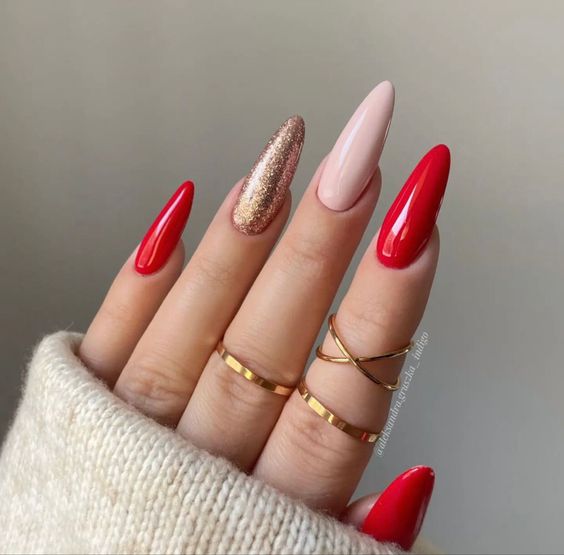 Imagem com Unhas almond decoradas com vermelho, glitter dourado e nude