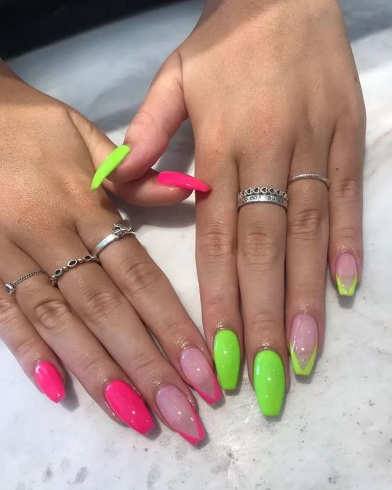 Imagem com Unhas almond decoradas com rosa neon em uma mão e verde neon em outra