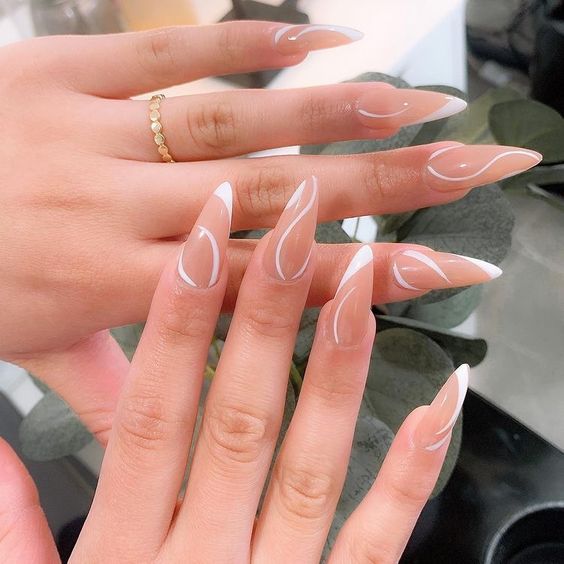 Imagem com Unhas almond decoradas com nude e branco