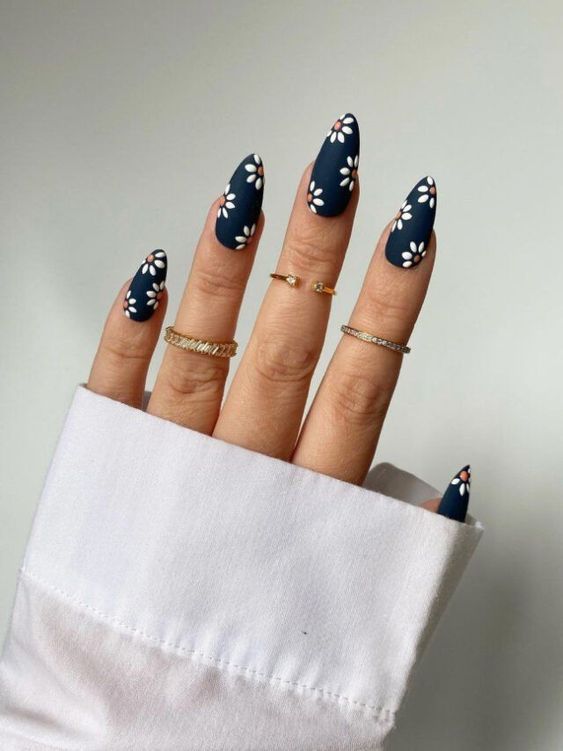 Imagem Com Unhas Almond Decoradas Com Azul Escuro E Flores Brancas Delicadas