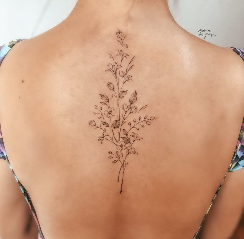 Imagem com tatuagem de flor nas costas: ramo