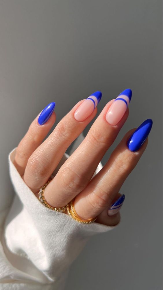 Imagem com Unhas almond decoradas com azul, nude e francesinha dupla azul