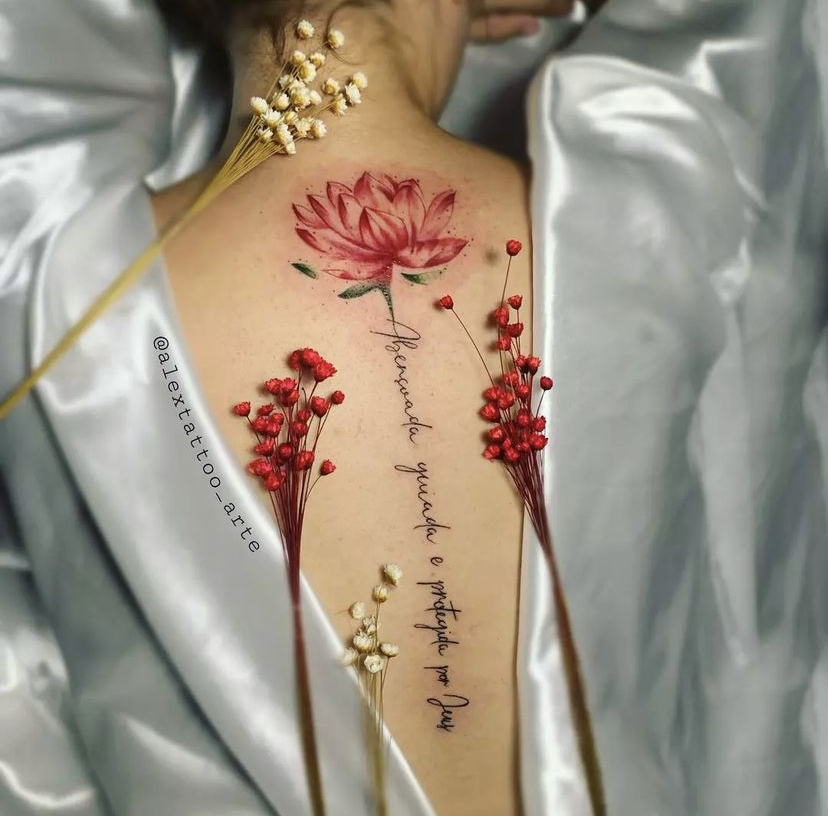 Imagem com tatuagem de flor nas costas colorida com frase