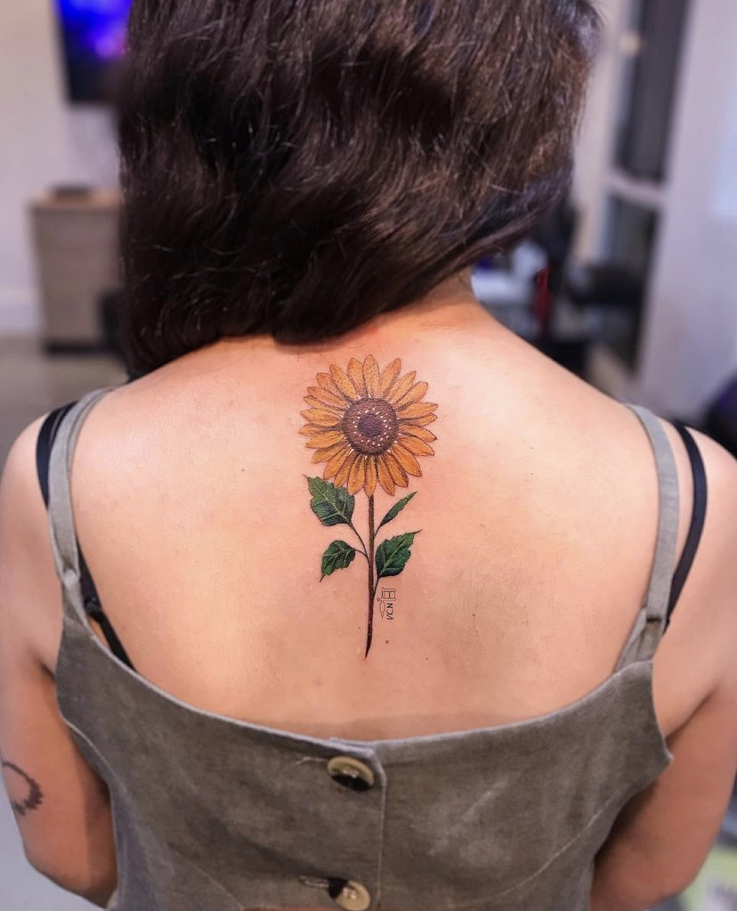 Imagem com tatuagem de flor nas costas: girassol