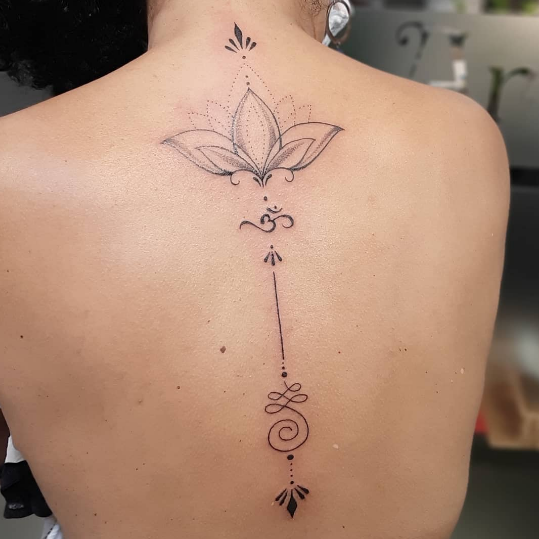 Imagem com tatuagem de flor nas costas: lótus e símbolos