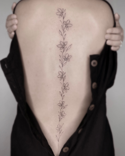 Imagem com tatuagem de flor nas costas: ramos na vertical