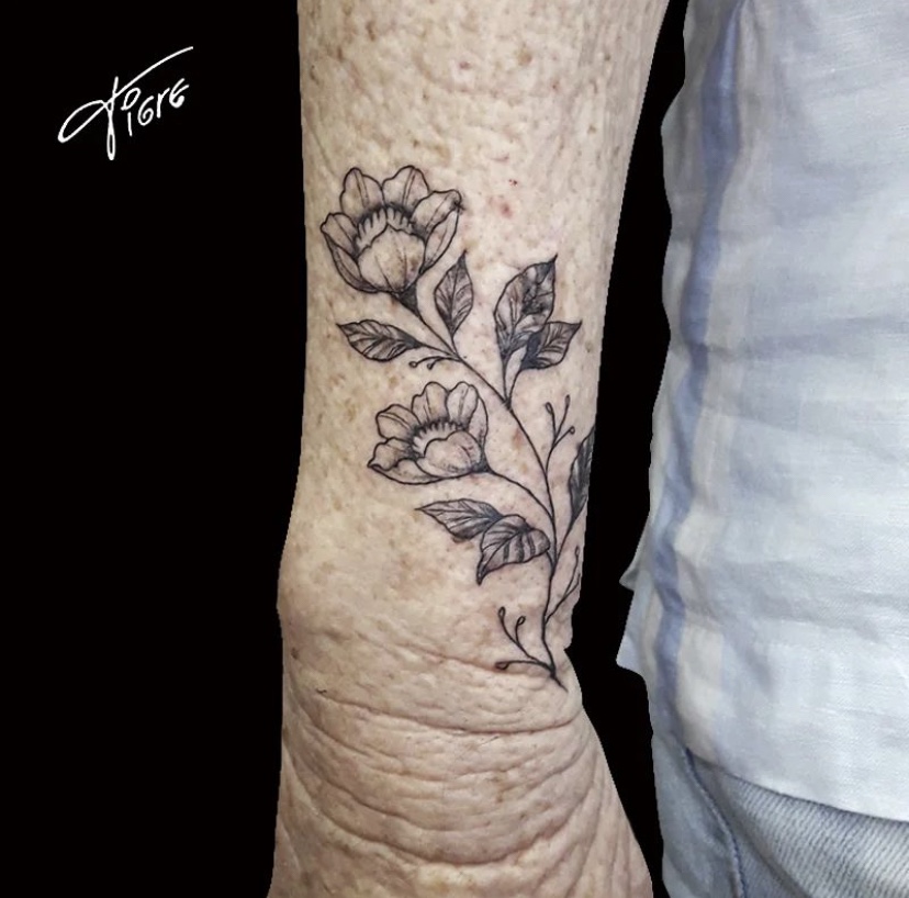 Imagem Com Tatuagem De Ramo E Flor No Braço