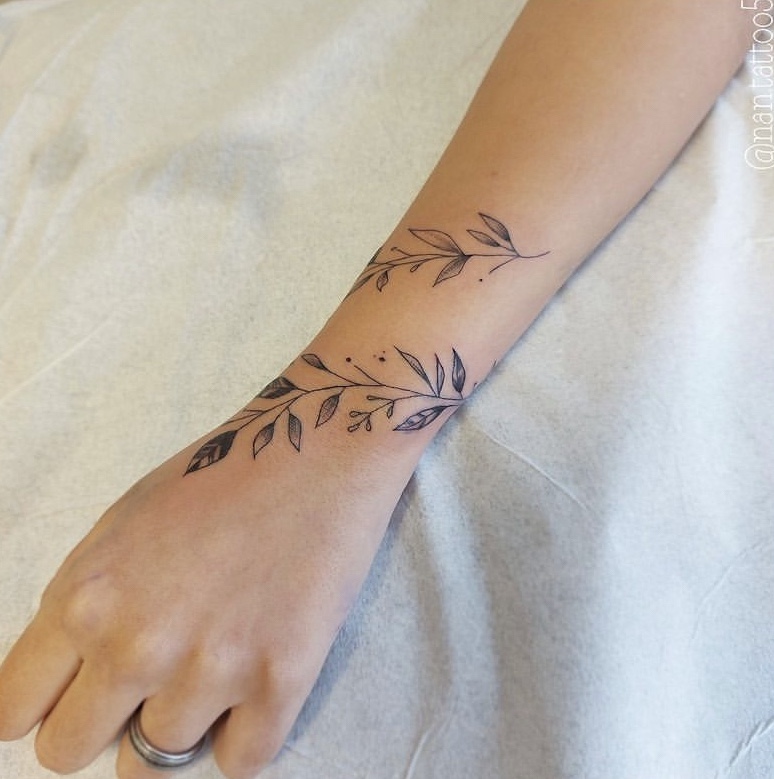 Imagem com tatuagem de ramo delicada no pulso