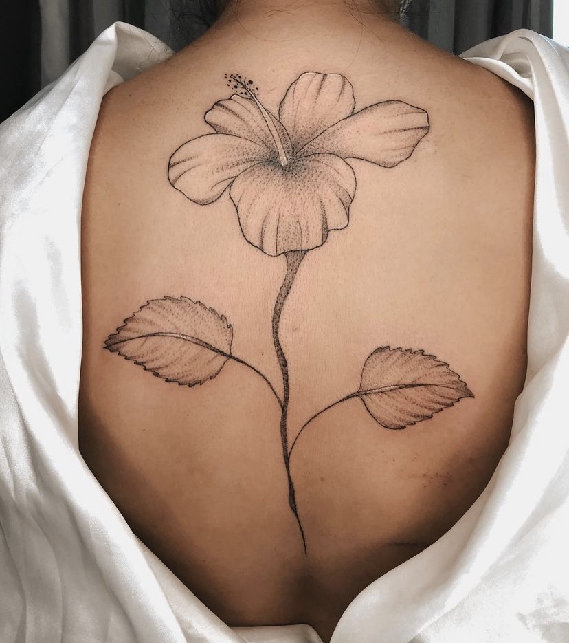 Imagem com tatuagem de flor nas costas: hibisco