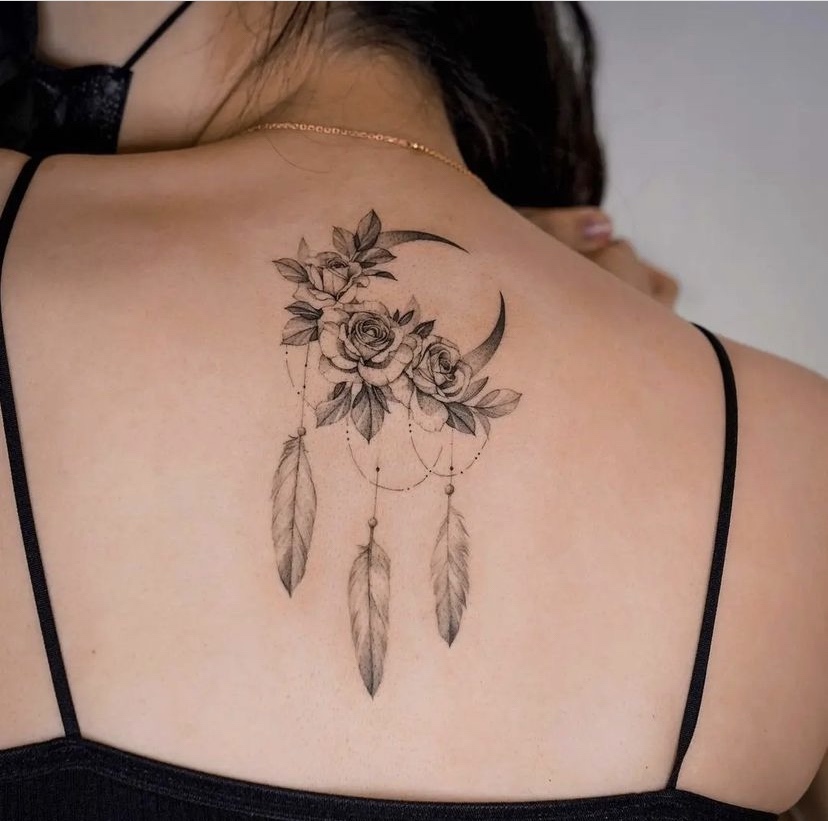 Imagem com tatuagem de flor nas costas com lua