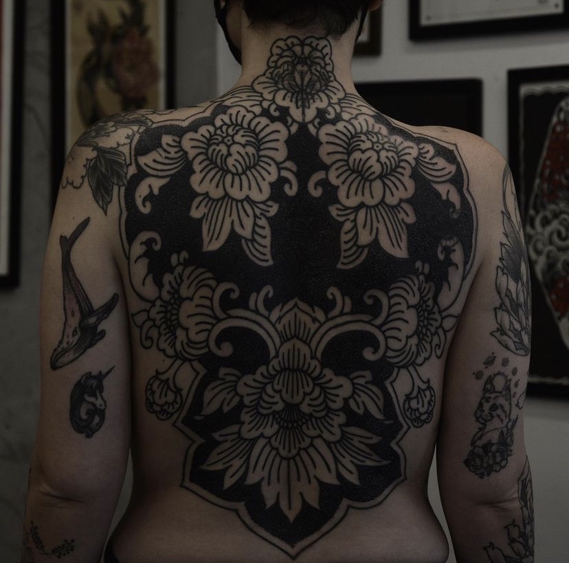 Imagem com tatuagem de flor nas costas robusta