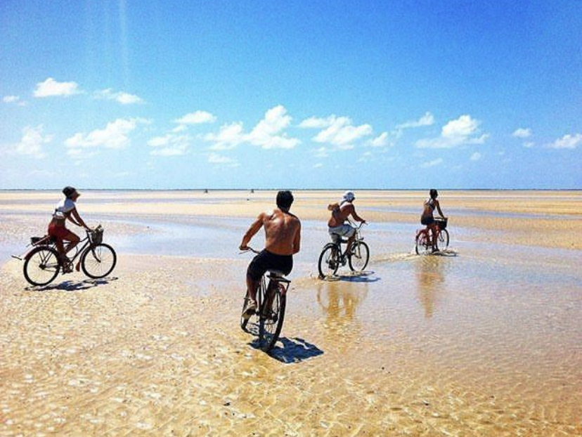 Imagem com passeio de bicicleta na praia