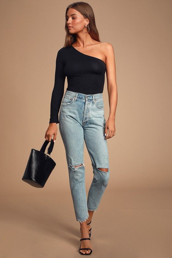 Imagem com blusa de um ombro só preta com jeans e brincos grandes