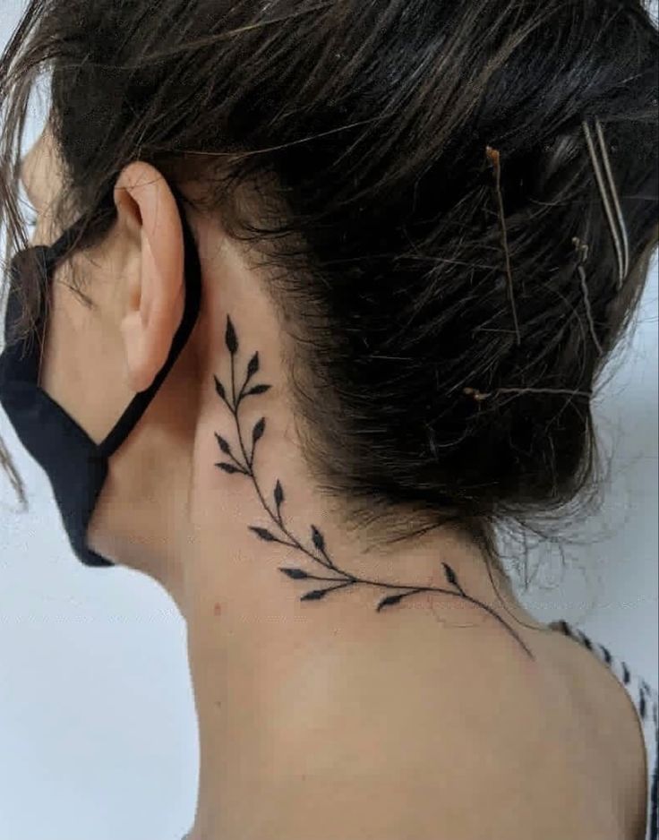 Imagem com tatuagem de ramo atrás da orelha