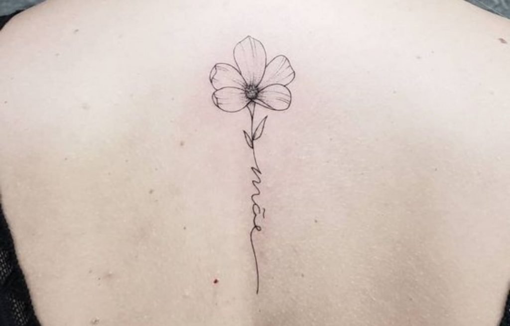 Imagem com tatuagem de flor nas costas e escrita "mãe"